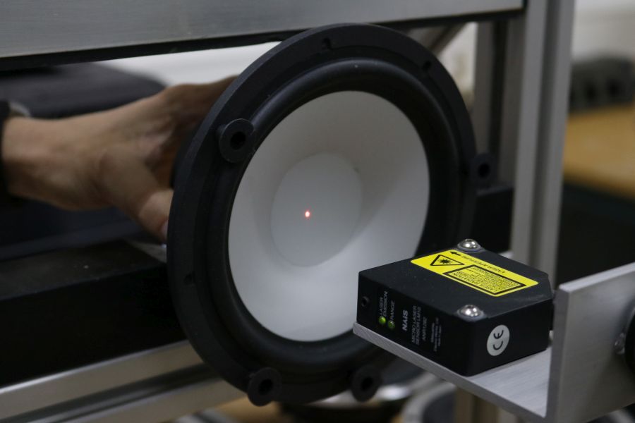 The woofer is placed on a special stand for a laser (the red dot) to measure the cone movements.